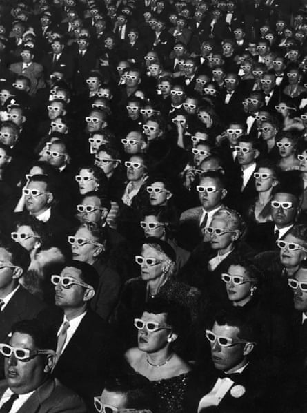 Black and white image of cinema-goers wearing 3D glasses during opening night screening of movie “Bwana Devil”. Hollywood, 1952