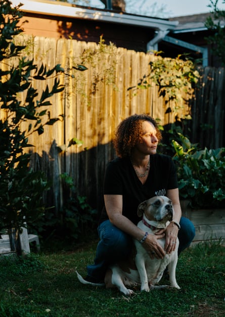 Woman pinch curly hairsbreadth squatting and caressing her dog