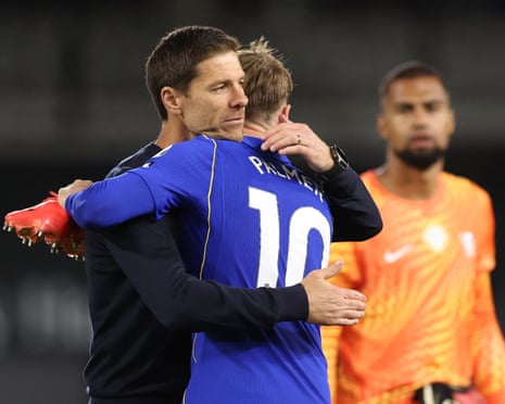 The Chelsea manager, Xabi Alonso, embraces his attacking midfielder Cole Palmer, while the goalkeeper Robert Sánchez looks on, after his team's 3-2 win at Fulham