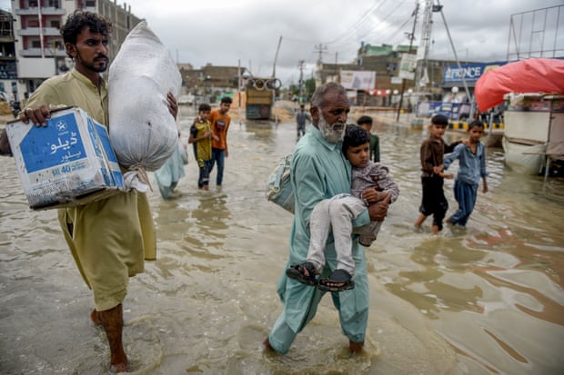 Karachi residents wade through a flooded street after a deluge this month.