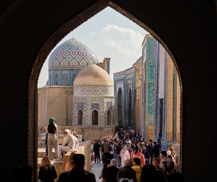 Richly decorated domes and buildings of Shah-i-Zinda in Samarkand, seen through an ogee arch