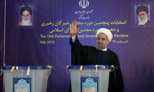 Iranian president Hassan Rouhani waves after casting his vote for parliament and the Assembly of Experts.