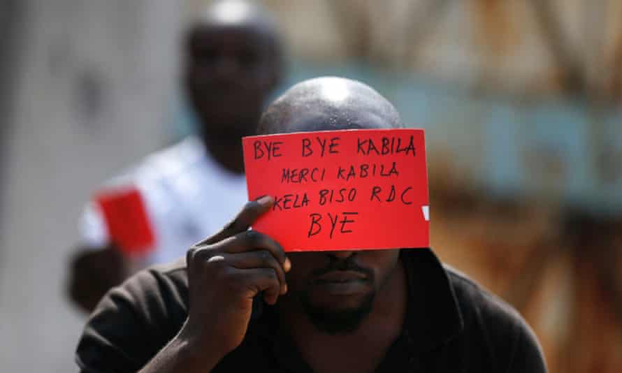 An opposition supporter displays a red card against President Joseph Kabila’s rule.
