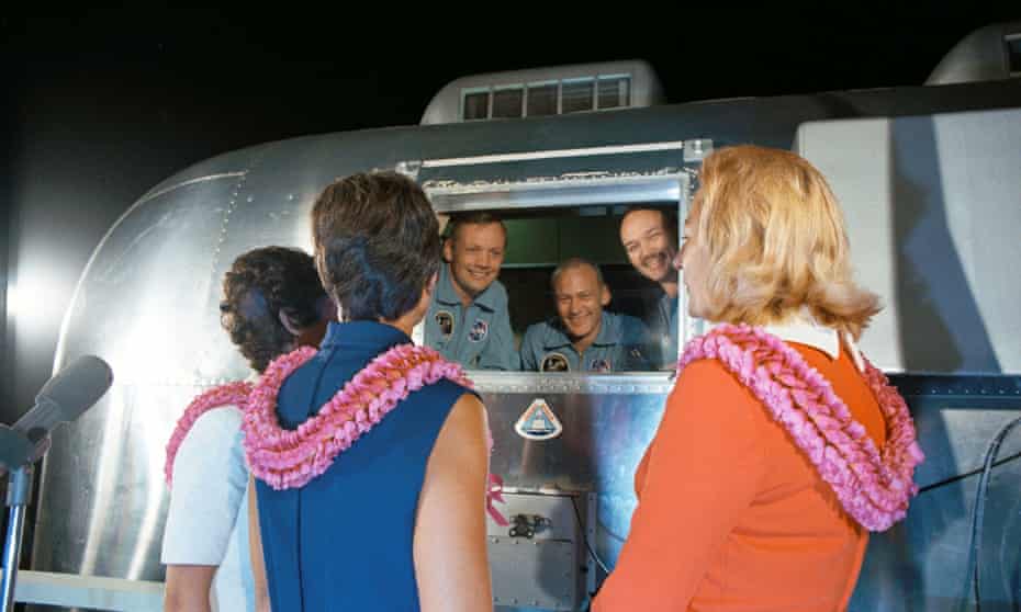 Neil Armstrong, Buzz Aldrin and Michael Collins speaking to their wives through the window of a mobile quarantine facility in July 1969.