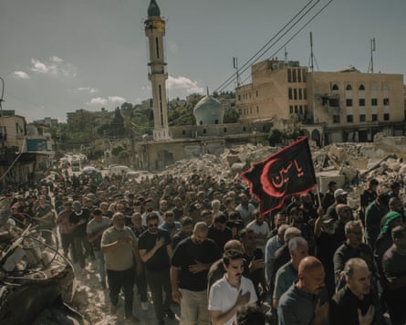 A convoy of group walks down a flag, pinch buildings and a minaret successful nan background