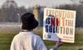 a protester holds a sign that reads "execution is not the solution"