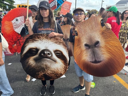Demonstrators at the Belém march carry large signs with the faces of rainforest animals on them