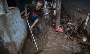 A man cleans mud from his Jakarta home