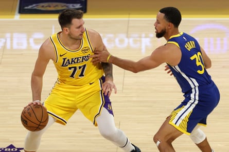Luke Dončić is guarded by Stephen Curry during Tuesday’s season opener.