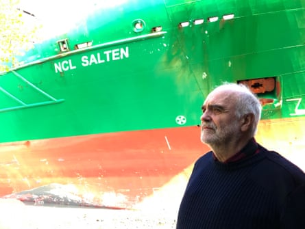 Johan Helberg stands beside the green and red hull of a ship