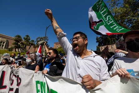 young man raises fist alongside other protesters