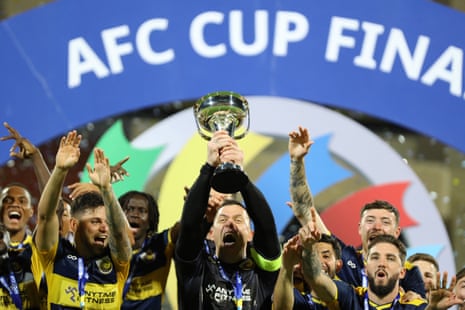 Central Coast Mariners players celebrate with the AFC Cup after beating Lebanon's Al-Ahed in Muscat.