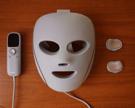 Shark CryoGlow LED face mask on a wooden tabletop.