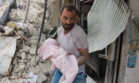 A Syrian man carries the body of an infant retrieved from under the rubble of a building following a reported airstrike on the al-Muasalat area of Aleppo.
