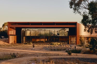 The Yitpi Yartapuultiku building with glass walls and rust-coloured steel beams at sunset