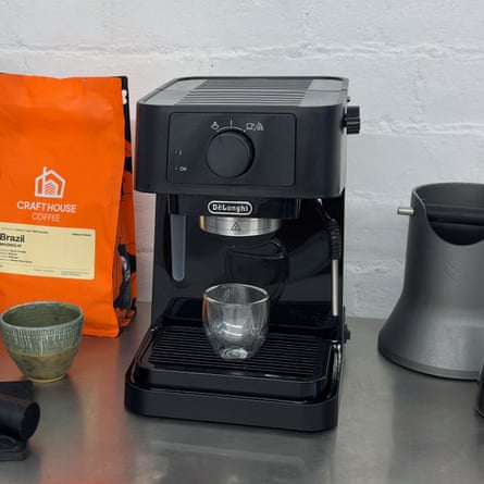 De’Longhi Stilosa EC230 on a worktop surrounded by coffee beans and various coffee-making accessories