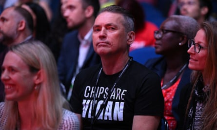 Dale Vince sits among the audience wearing a T-shirt with the slogan ‘Chips are vegan’