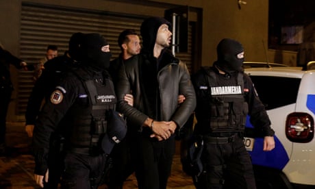 Andrew Tate is led away by police after a house raid in Bucharest, Romania.