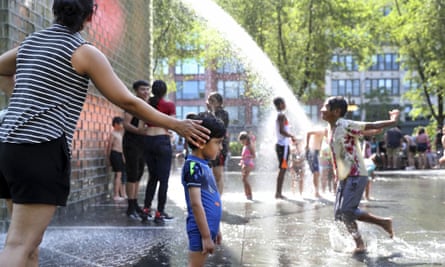 As crianças brincam em uma fonte em um parque da cidade