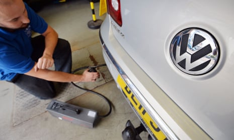 A Volkswagen Passat car is tested for its exhaust emissions by a mechanic at an MOT testing station in Walthamstow, London
