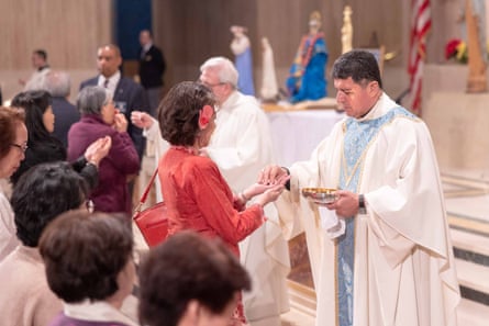 a man in a church gives communion to a woman