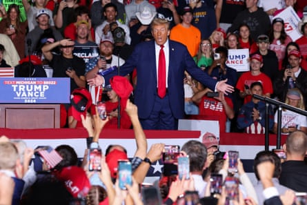 trump holds out hands in front of crowd