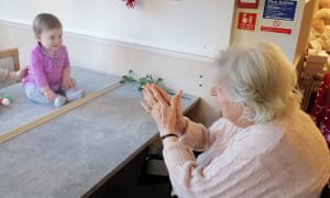 Margot Lawson meets her great-granddaughter, Cecilie, for the first time behind a glass partition in her care home in Surbiton, London, last week. Photograph: CHD Living/PA