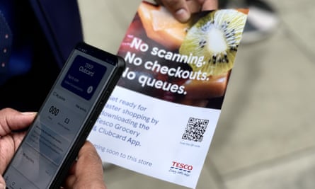 A Tesco employee holds out a leaflet at the GetGo store