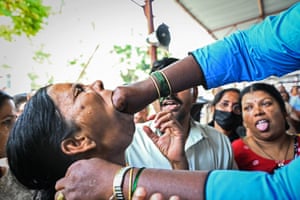 A woman with a man’s hand in her mouth