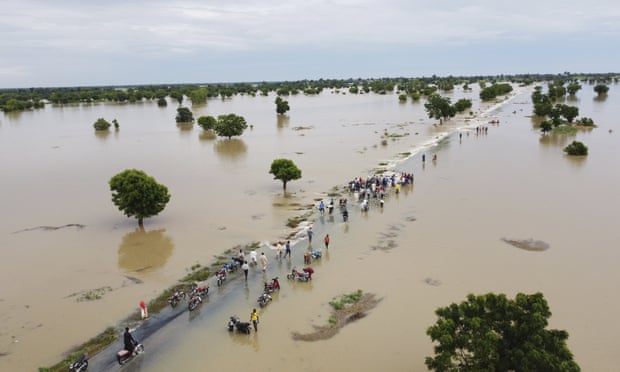 People walk through floodwaters after heavy rainfall in Hadeja, Nigeria.