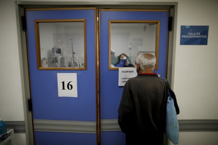 A man keeps vigil for his wife, who is suspected of having Covid-19, at a hospital in Argentina