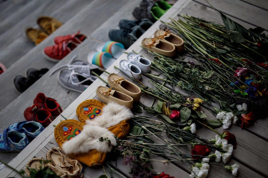 Flowers, shoes, and moccasins sit on the steps of the main entrance of the Mohawk Institute in Brantford, Ontario, to honor the children who died.