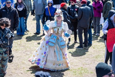 Boston, MassachusettsA demonstrator dressed as Marie Antoinette holds a sign reading: ‘Oh la la, let them eat Trump coin.’