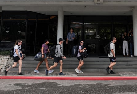 People walking past the entrance to the Hard Rock hotel, carrying their bags