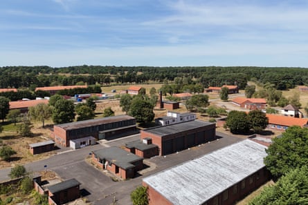 An aerial view of the military site, showing several brick buildings of various sizes on a tarmac surface set in the countryside
