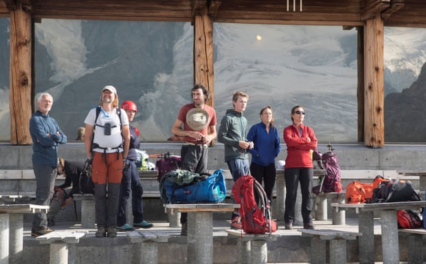 glacier reflected in window behind hikers