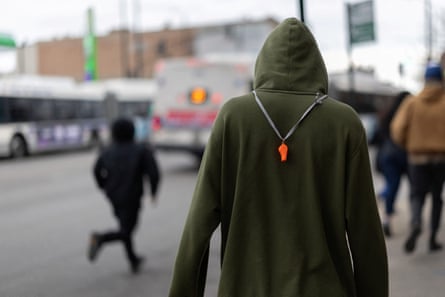 a person in a green hoodie wears a whistle