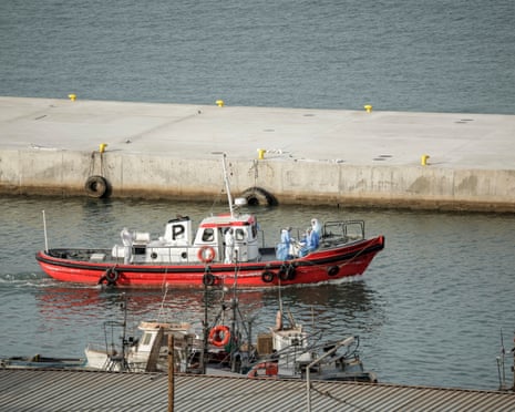 Crew members wearing hazmat suites leave the port on an ambulance boat towards the cruise ship MV Hondius, while stationary off the port of Praia, the capital of Cape Verde.