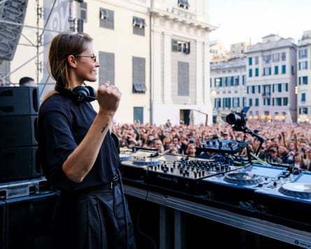 Charlotte de Witte clenches a fist as a large crowd watches her performance