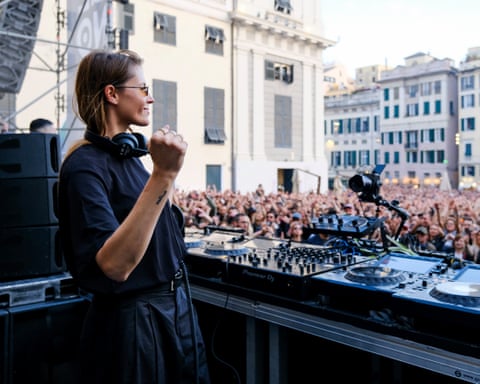 Charlotte de Witte clenches a fist as a large crowd watches her performance