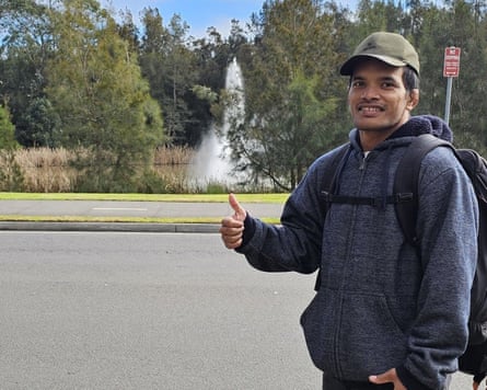 Man raises his thumb with a water fountain in the background