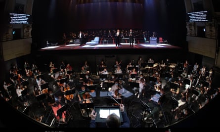 The Teatro Real orchestra in face masks, with the conductor separated by screens.