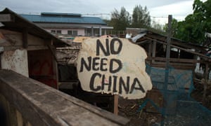 David displays a sign next to his betel nut stand conveying his feelings about the diplomatic change his country has made.