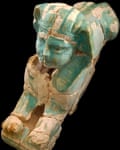 A sphinx-like stone sculpture, partly green in colour