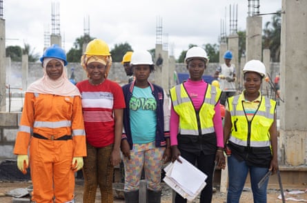 A line of women wearing hard hats on a construction site.