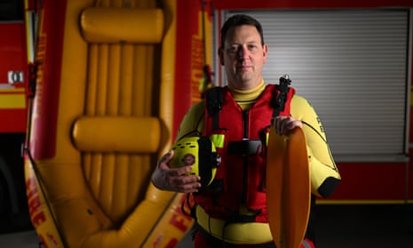 Swift-water rescuer Brad Mitchell wearing a life jacket and standing beside an inflatable raft