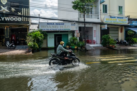 A motorcyclist driving down a flooded street in Ca Mau, Vietnam, on November 12, 2025.