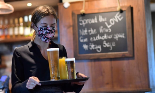 A woman delivers drinks in a pub