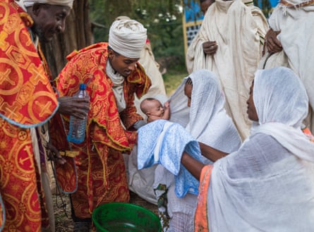 A baby is baptised before divine liturgy on a Sunday morning at Robit Bahita church