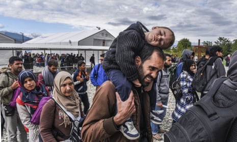 Migrants and refugees stand in line as they wait to board a train at the registration camp after crossing the Macedonian-Greek border near Gevgelija on September 28, 2015.